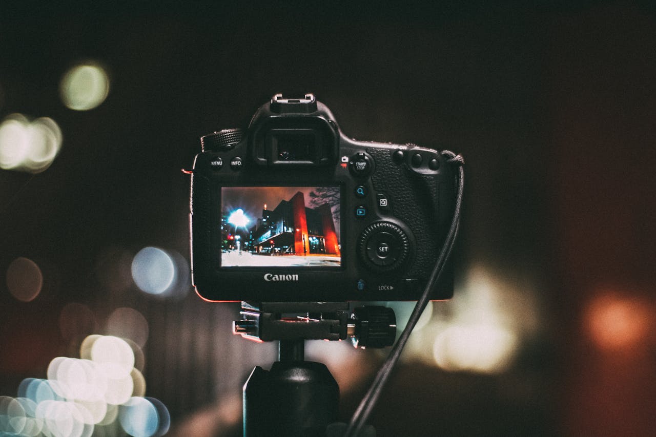 why-choose-us Close-up of a camera capturing a vibrant urban scene at night with a blurred bokeh background.