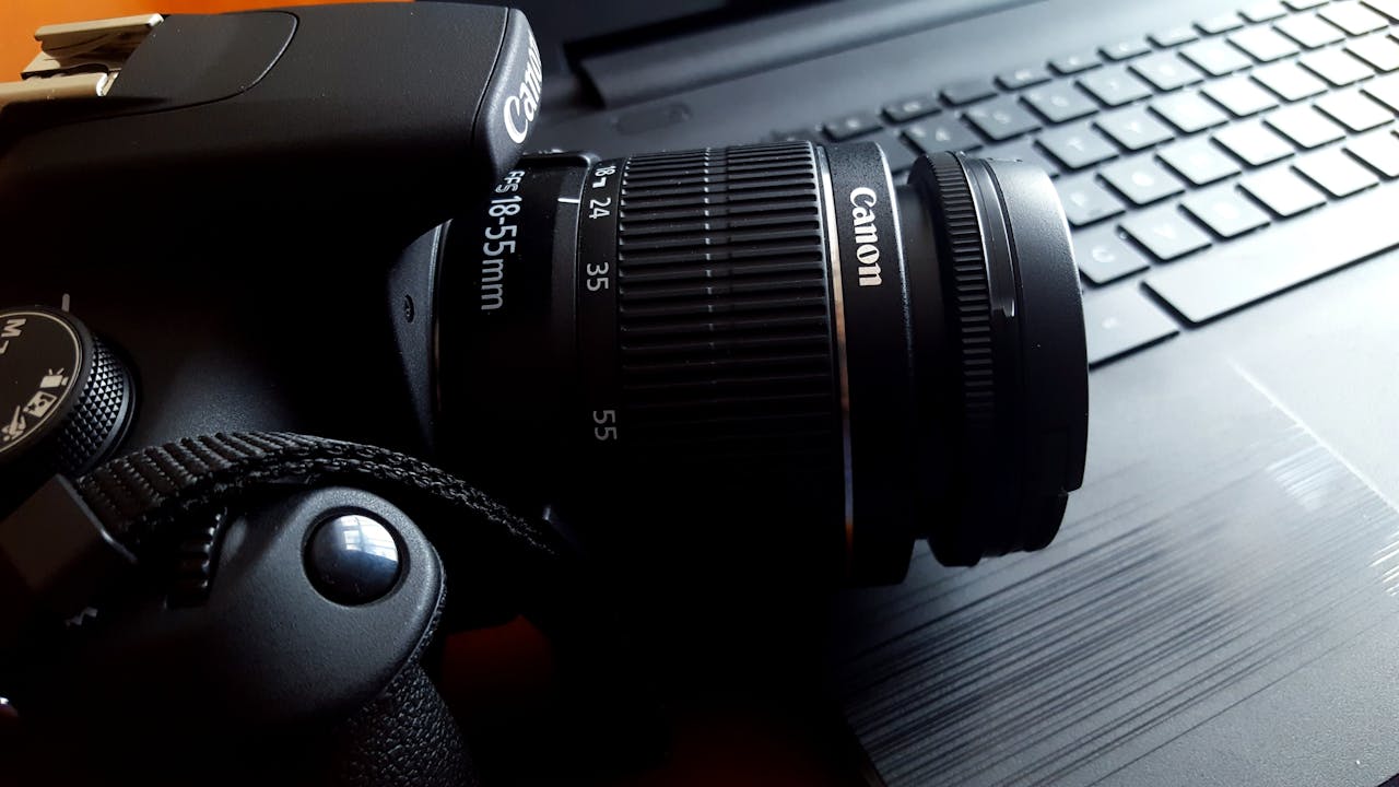 journey Close-up of a black DSLR camera with lens on a laptop keyboard.